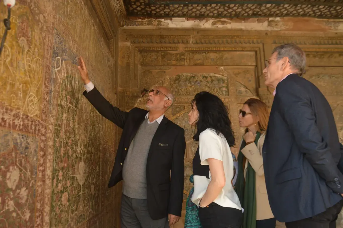 Licensed guide explaining Mughal frescoes to international guests in Lahore