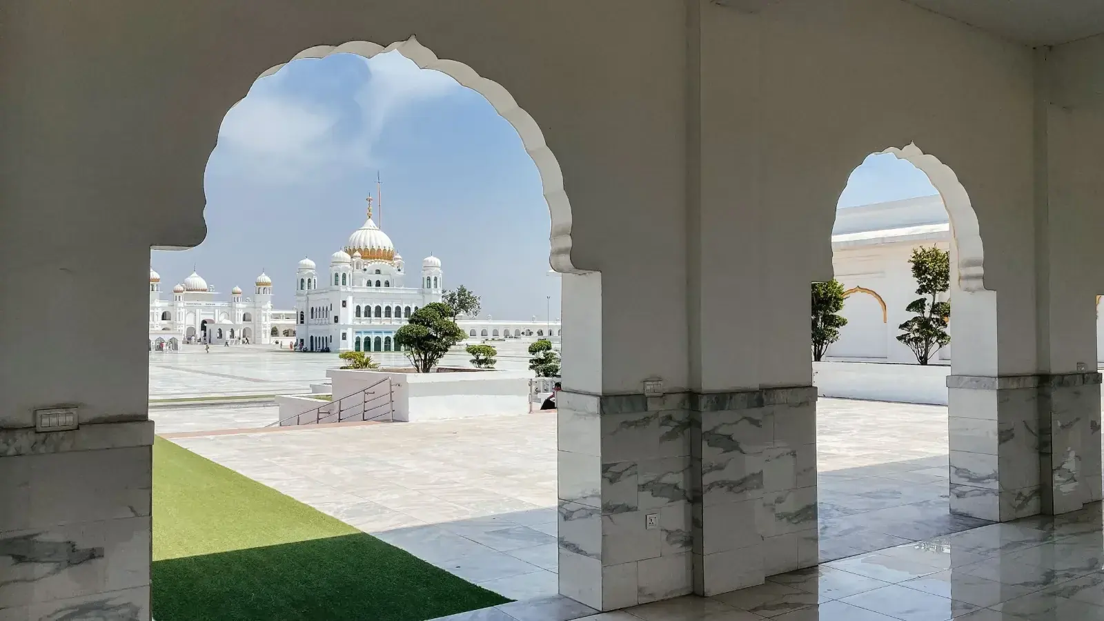 Kartarpur Sahib complex viewed through a white marble arch