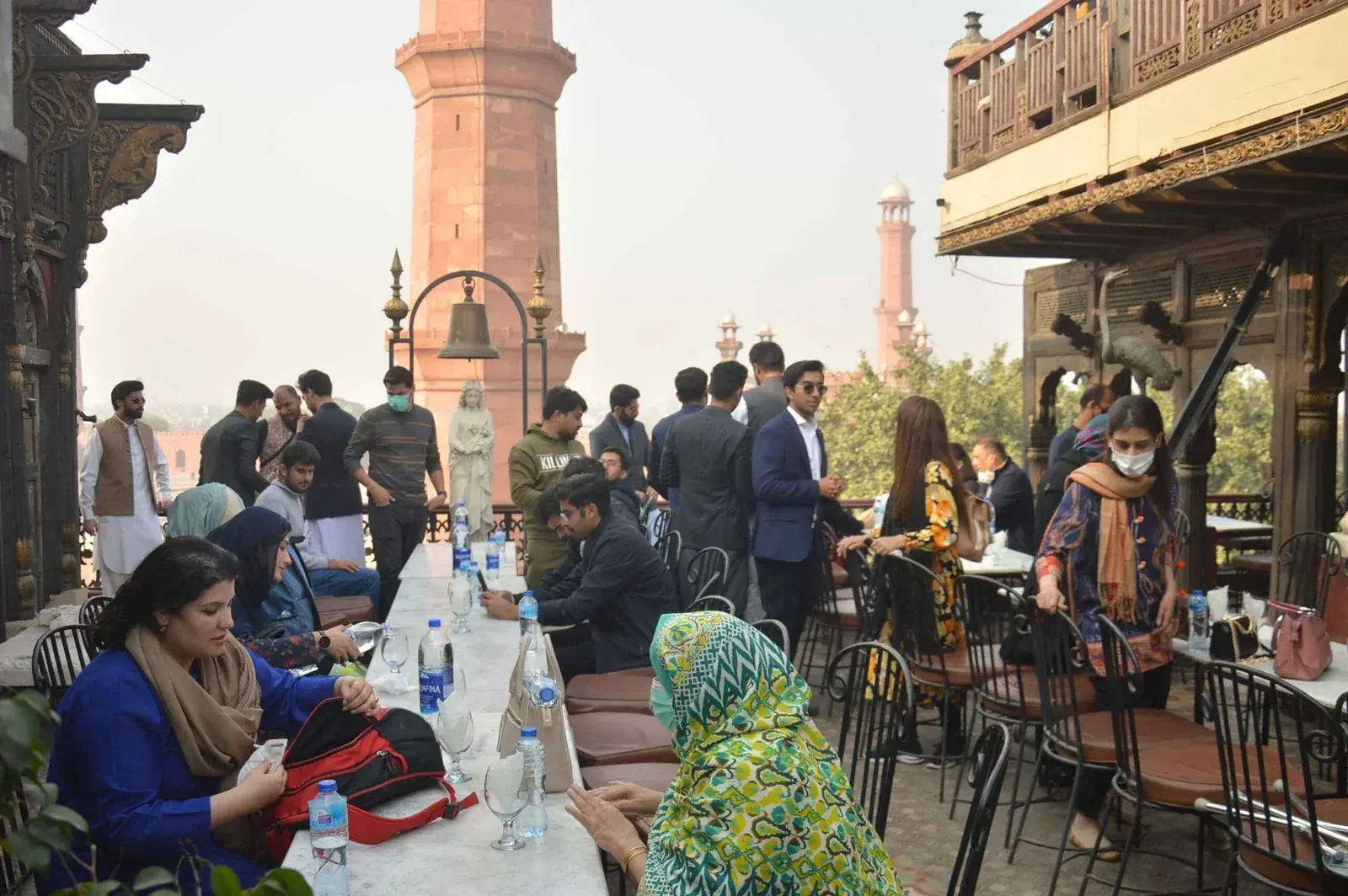 Guests dining at a rooftop restaurant overlooking historic Lahore